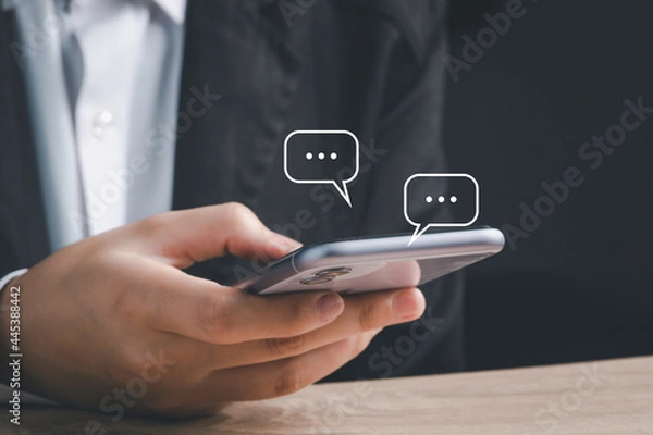 Fototapeta Live Chat on Communication social network Concept.  Hand using smartphone typing, chatting conversation in chat box icons pop up.