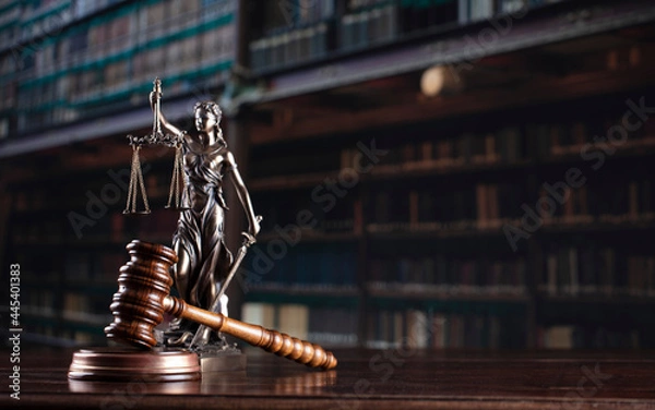 Fototapeta Law theme. Themis statue and judge gavel in the law faculty library.
