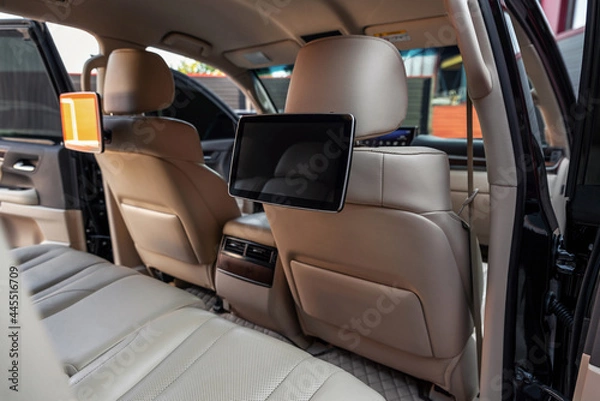 Fototapeta Car inside. Multimedia screens or TV displays for rear passenger seats. Luxury car interior with leather seats.