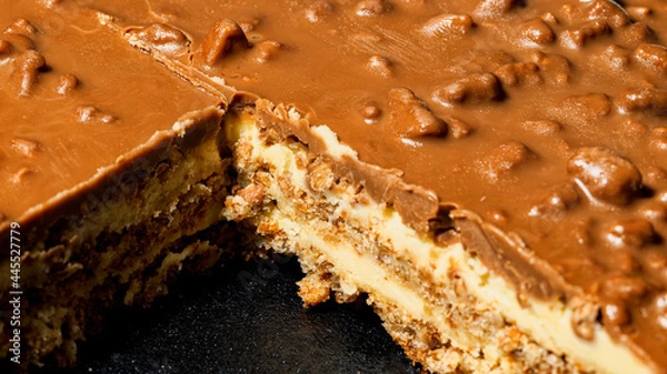 Fototapeta Slice of Swedish almond and chocolate cake with filling and nuts