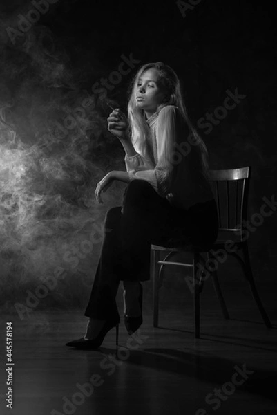 Obraz A girl in a white blouse is sitting on a chair with a cigarette in her hands, there is smoke around. Depression, feminism, loneliness, strong woman, independent, thoughts, reflections, bad habits