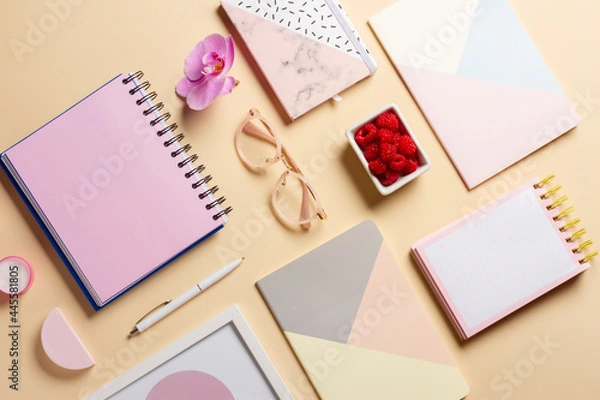 Fototapeta Composition of notepads, pen, flower, raspberries and candles on a delicate background