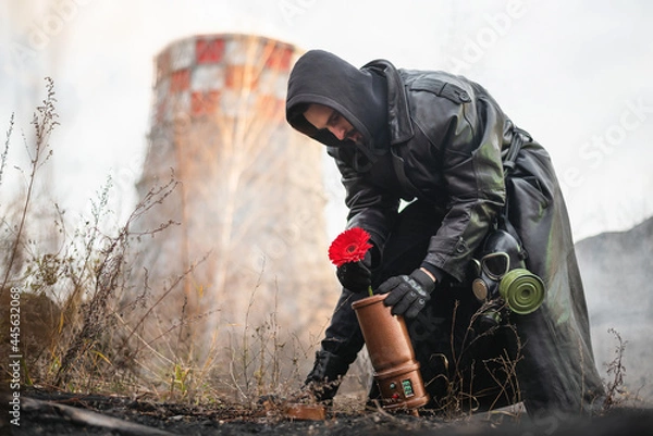 Fototapeta Post apocalypse soldier is collecting a red gerbera flower into the safety container concept.