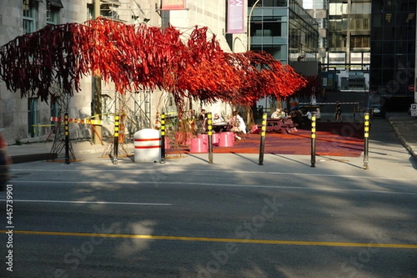 Fototapeta Montreal, QC, Canada - 7-14-2021: The Urban Forest at the street next to McCord museum, Sherbrooke street west with people enjoying their time after the ease of the lockdown of coronavirus. Green Zone