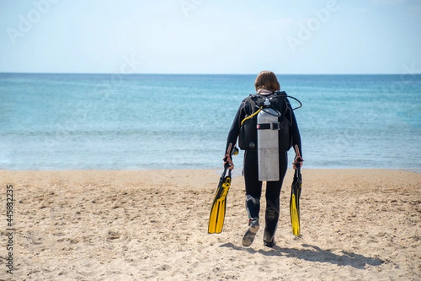 Obraz Scuba Diver. Diver girl walks along the beach towards the sea