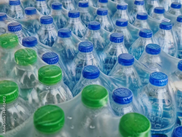 Fototapeta High Angle View of Packs of Bottled Drinking Water with Blue and Green Caps
