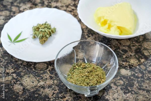 Obraz Ingredients to prepare cannabis butter or cannabutter. Kitchen table with marijuana and butter for cooking.