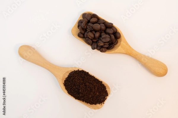 Fototapeta Coffee beans and ground coffee in wooden spoon isolated on white background.