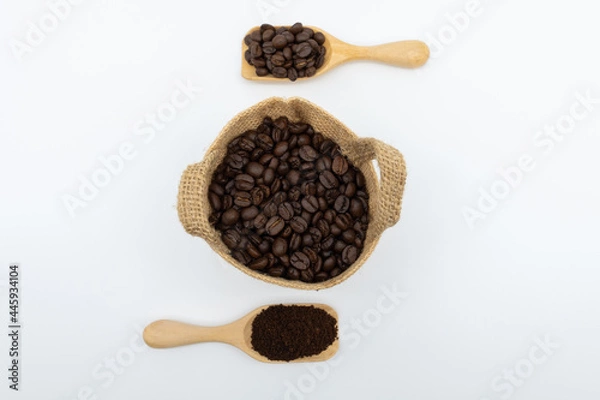 Fototapeta Coffee beans and ground coffee in wooden spoon with hemp sack bag isolated on white background.