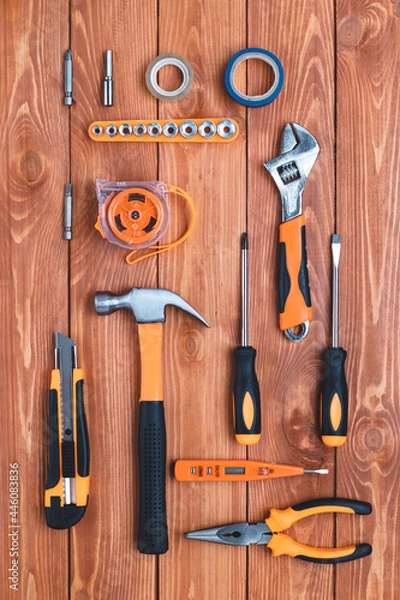 Obraz Set of construction tools on a brown wooden background. Hammer, wrench, pliers and screwdriver. Greeting card for the holiday Labor Day, Father's Day. Equipment, workplace. DIY concept. Flat lay.