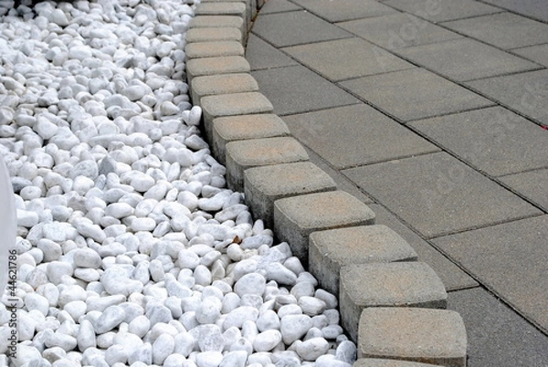 Fototapeta flower bed border made of pebbles and stones