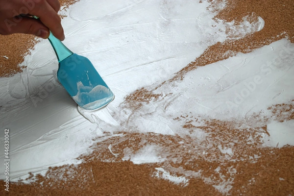 Obraz A man applies white plaster with a spatula