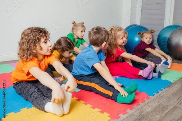 Fototapeta Children exercising while physical education lesson at preschool