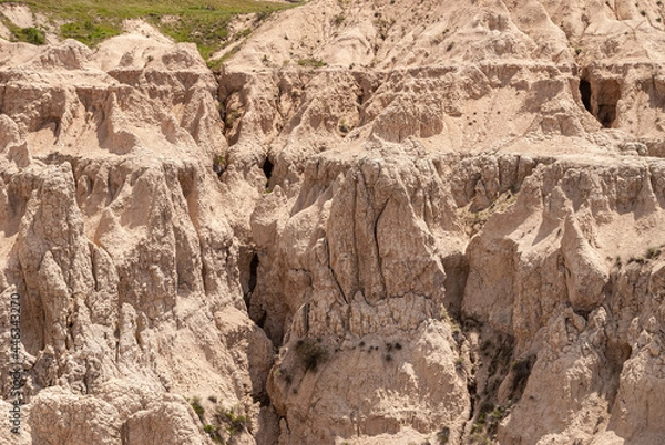 Fototapeta Badlands National Park, SD, USA - June 1, 2008: Detail of sharp beige canyons among peaks of geological deposits.