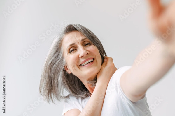 Obraz Grey senior woman laughing while reaching her hand to camera