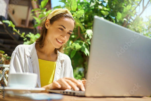 Obraz Close-up portrait young business woman working and typing on laptop computer, checking notification for laptop system, working in cafe during vacation
