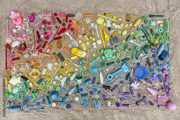 Fototapeta Colorful Plastics Found on the Beach Arranged into a Rainbow on a Sandy Beach Flat Lay Out