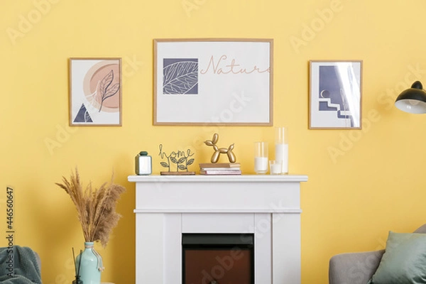 Fototapeta Fireplace with decor and pictures hanging on color wall