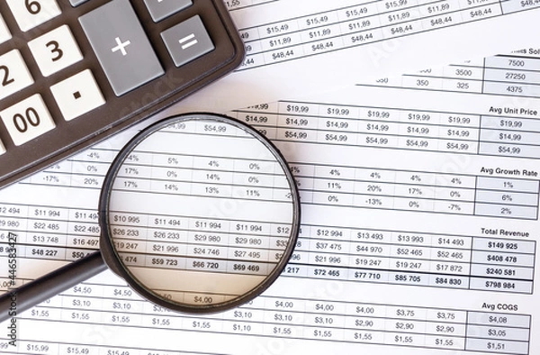 Fototapeta Calculator and magnifier with accounting and financial reporting on the table.