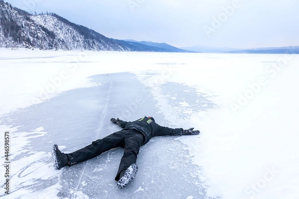 Fototapeta a man lying on ice in winter