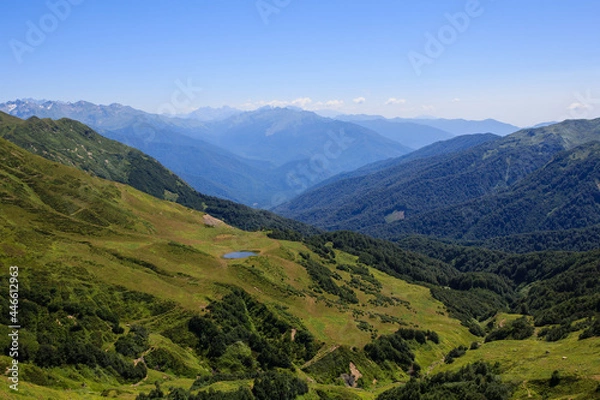 Fototapeta small mountain lake on the alpine meadows and valley covered with forest in caucasus