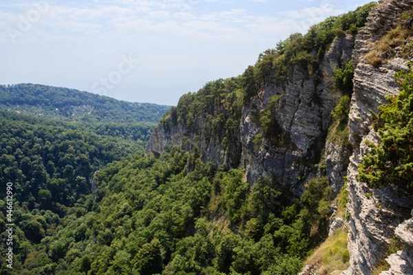 Fototapeta small village in caucasus mountains and high rocks covered with greenforest and pine trees