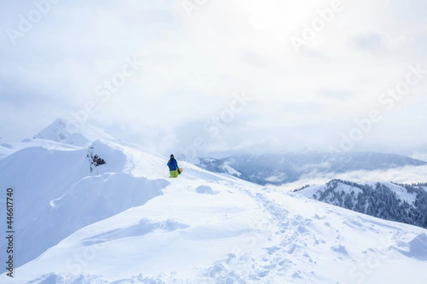Fototapeta freeride backcountry snowboarder on the trail on mountain ridge covered with snow powder