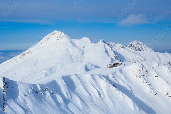 Fototapeta peak and cafe on the top of the ridge in snowy caucasus mountains in ski resort