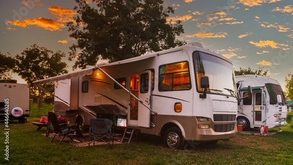 Obraz Sun going down at the Rv park with lights on the motor home 