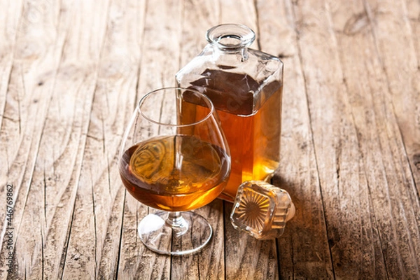 Fototapeta Cognac or whiskey drink on rustic wooden table. 