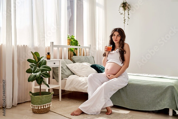 Fototapeta a beautiful pregnant woman eats right and drinks fresh natural juice