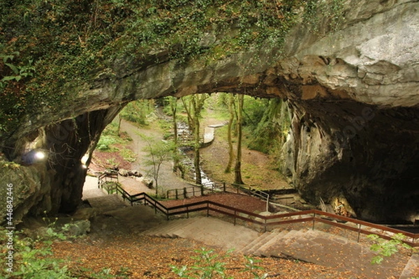 Fototapeta Zugarramurdi caves with lots of vegetation and a river in the background