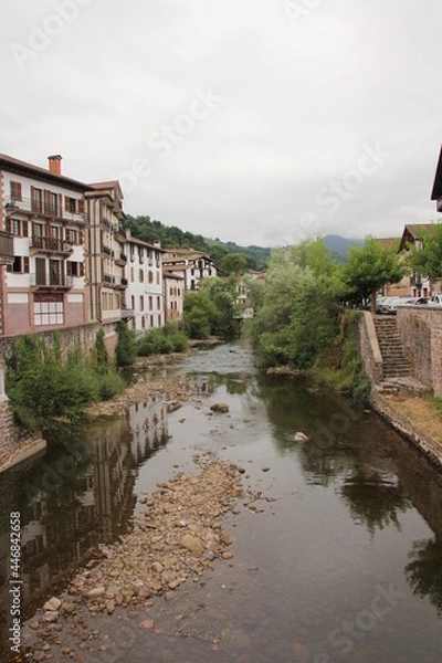 Fototapeta River with stones and with the reflection of the houses in Elizondo