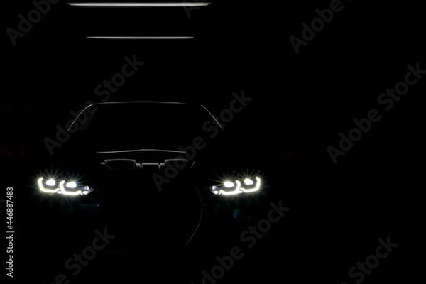 Fototapeta Unclear shape of front view sport car with headlights on dark background, Concept car concept, secret, new model car launch
