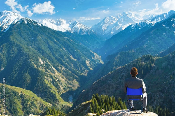 Fototapeta businessman at the top of the mountain is thinking