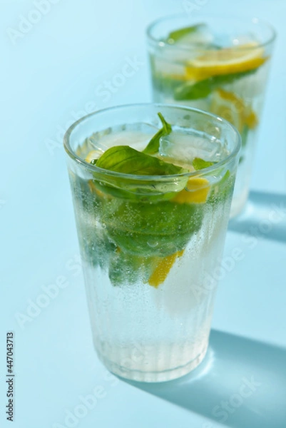 Fototapeta Glasses of tasty lemonade with basil on color background