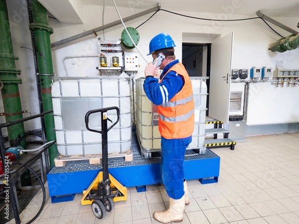 Obraz Calling worker. Industrial engineer using phone in industry room.
