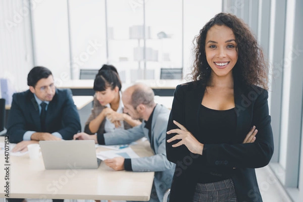 Fototapeta Portrait of cheerful confident businesswoman arms crossed smiling in modern office