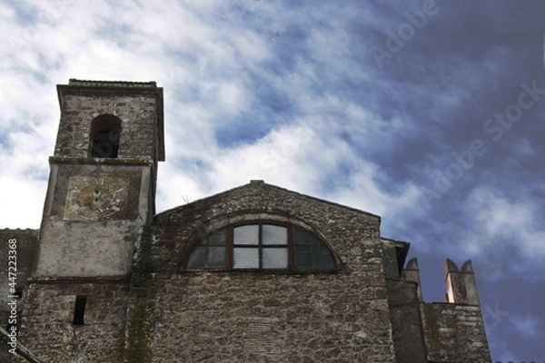 Fototapeta Detail of the Baronial Castle, XI-XII century, of Calcata, Italy. Tower and crenellated walls with cloudy and gray sky. Calcata, Italy.