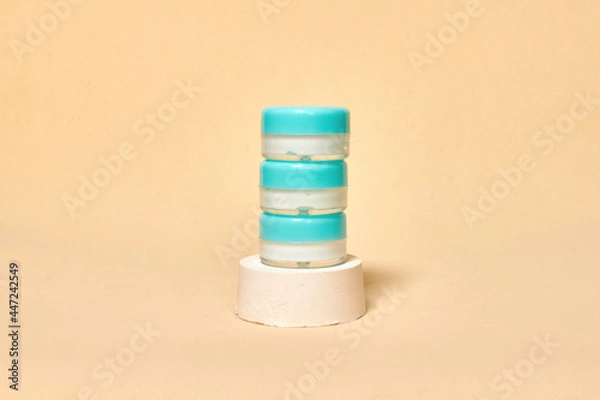 Fototapeta Cosmetics container on the pastel background. Earth colors, zero waste containers. Mockup concept. Minimal boxes and geometric podium. Scene with geometrical forms. 