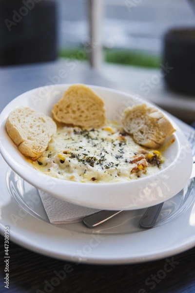 Fototapeta Vertical shot of a fancy pasta dish with bread on the plate served in a circular white bowl