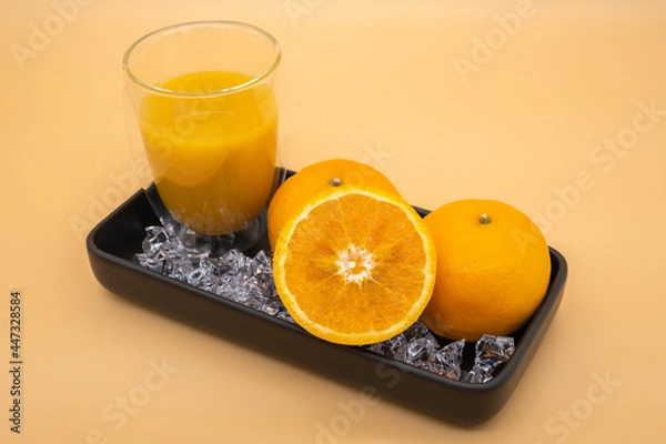 Fototapeta Fresh oranges in black ceramic plate with orange background.