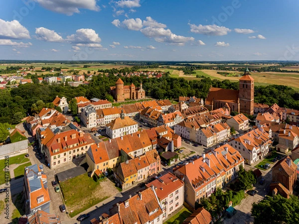 Fototapeta Panorama of the city of Reszel - Castle and the Church of Saint Apostles Peter and Paul in Reszel, town hall and buildings with red roofs