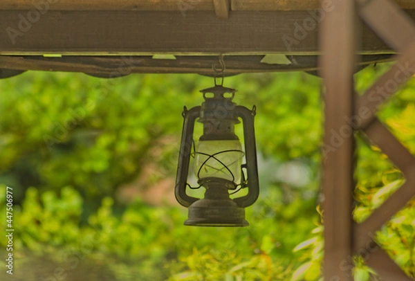 Fototapeta Stara lampa naftowa, wisi pod dachem . An old kerosene lamp hangs under the roof .