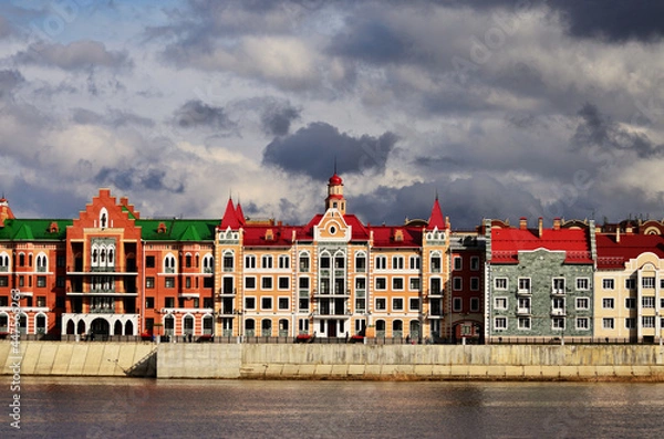Fototapeta A panorama of the building on the embankment of Bruges under gloomy clouds. Russia Yoshkar Ola 01.05.2021. High quality photo