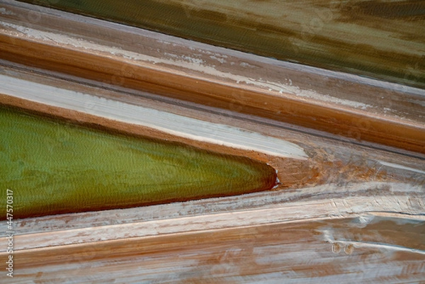 Obraz Abstract aerial view of blue-green water in shifting red deposition of sediment gradually moving through alluvial plains of Francois Peron National Park in Western Australia.