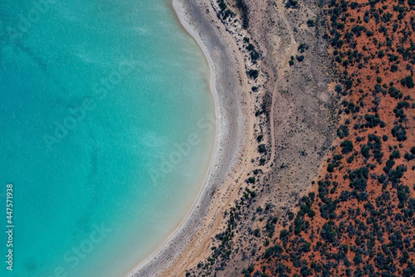 Obraz Abstract aerial view of blue-green water in shifting red deposition of sediment gradually moving through alluvial plains of Francois Peron National Park in Western Australia.