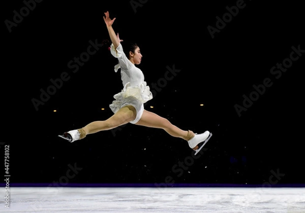 Fototapeta Mid air split jump performed by a professional ice skater