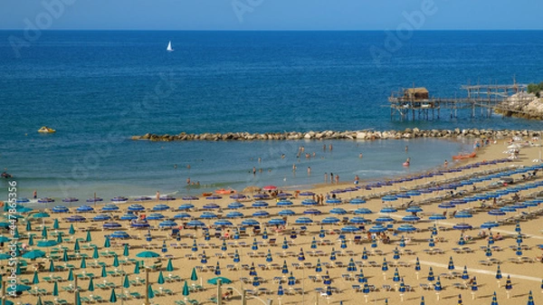 Fototapeta Panoramic view of Sant'Antonio beach full of umbrellas with its peculiar fishing trebuchet on the background , Termoli , Molise , Italy