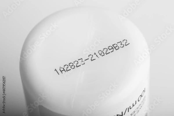 Fototapeta Lot number and manufacturing date on the bottom of the product with isolated white background.
